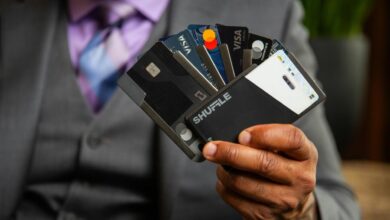 a man in a suit holding four credit cards