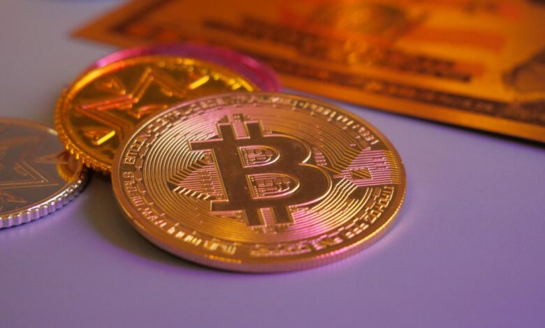 Golden bitcoin coin with other coins and card.