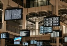 a bunch of television screens hanging from the ceiling