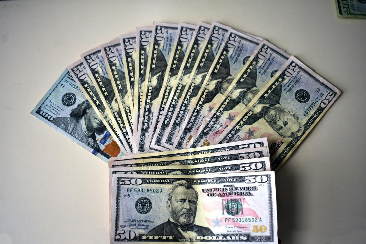 Fan of fifty dollar bills on a white surface