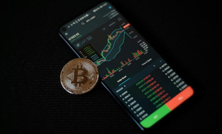 a bitcoin sitting on top of a smart phone