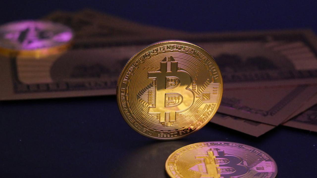 Bitcoin coin with us dollars in the background.