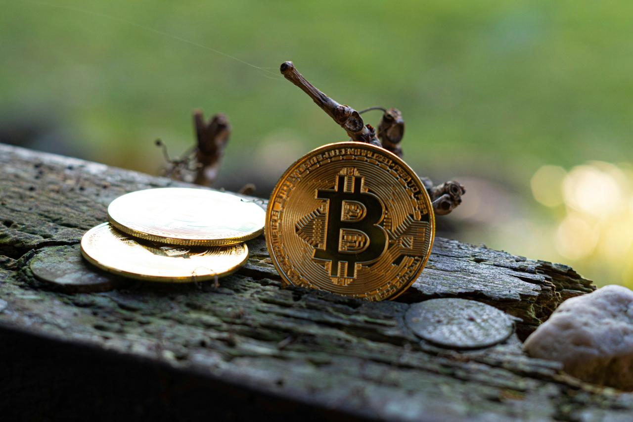 Golden bitcoins resting on a weathered wooden surface.